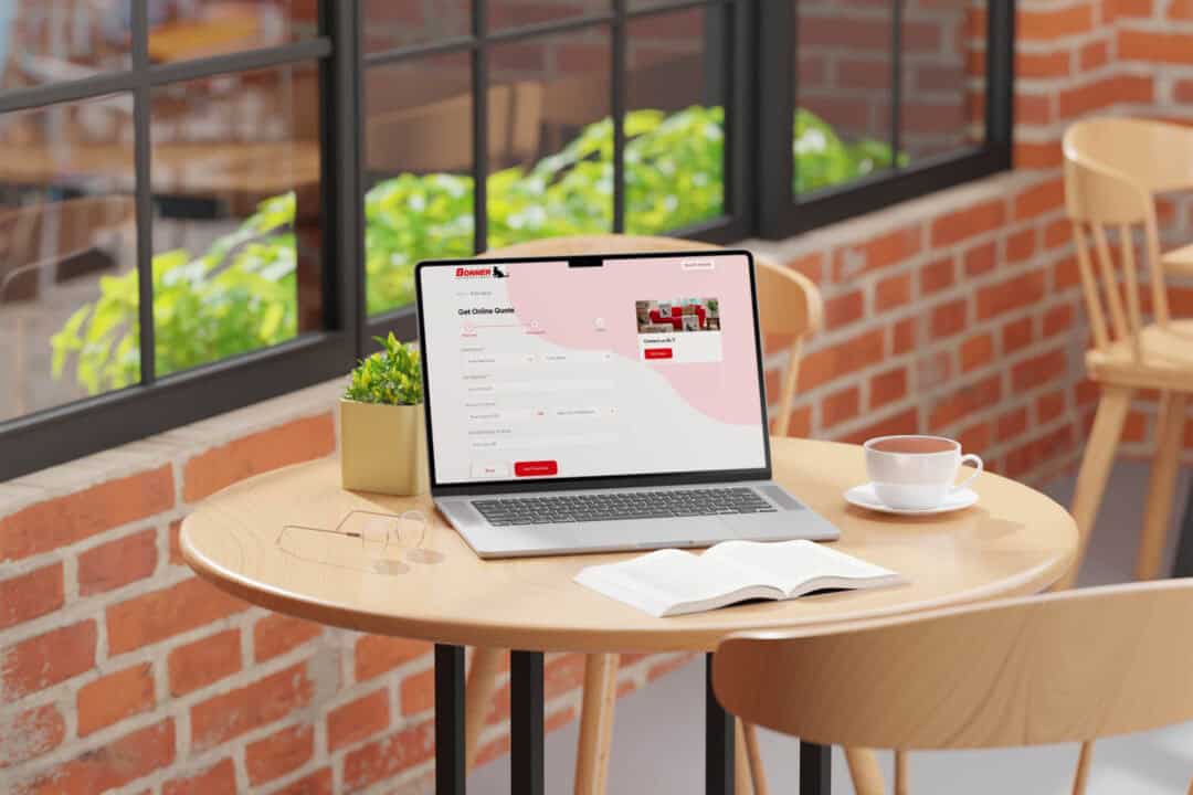 A laptop in a coffee shop displaying the Doree Bonner International website