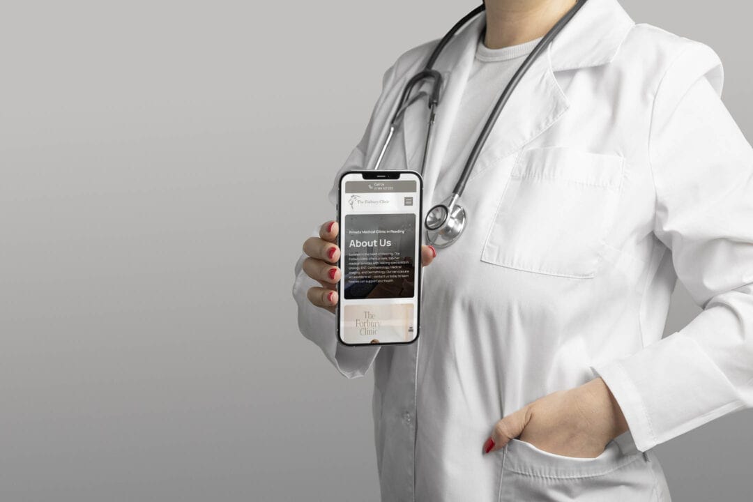 A doctor holding a smartphone that shows The Forbury Clinic about page