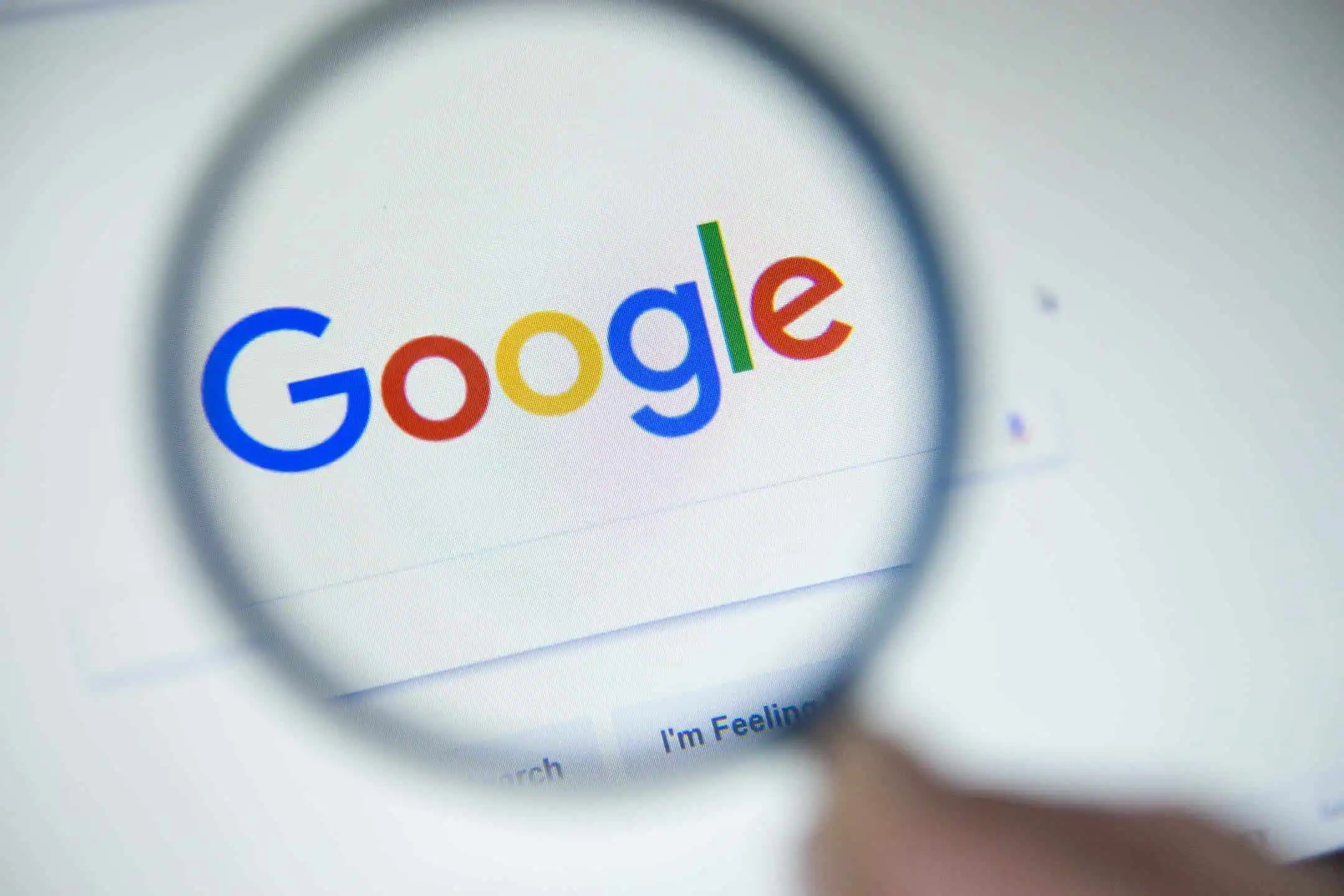 The Google homepage on a screen under a magnifying glass