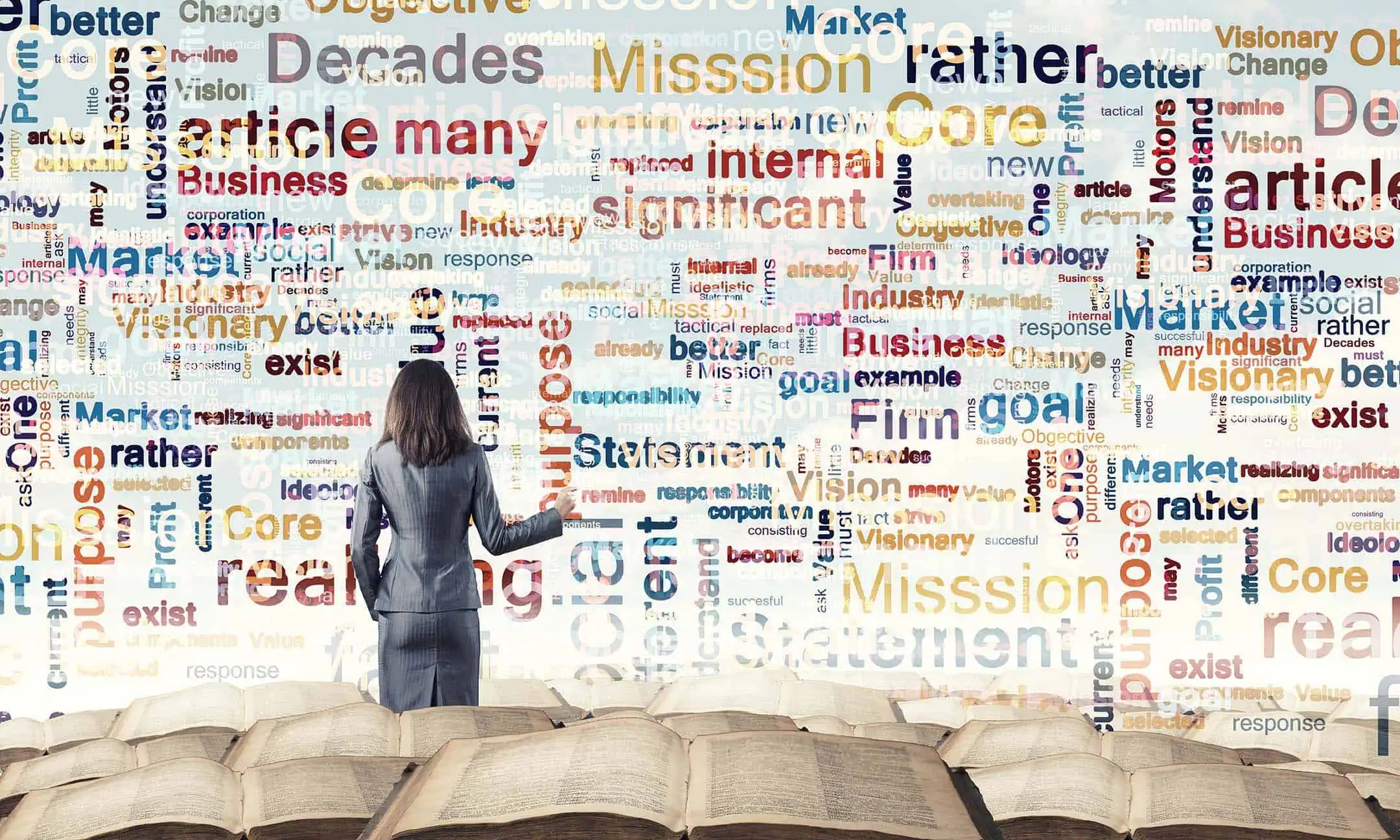 A woman standing in front of a wall filled with a complex word cloud