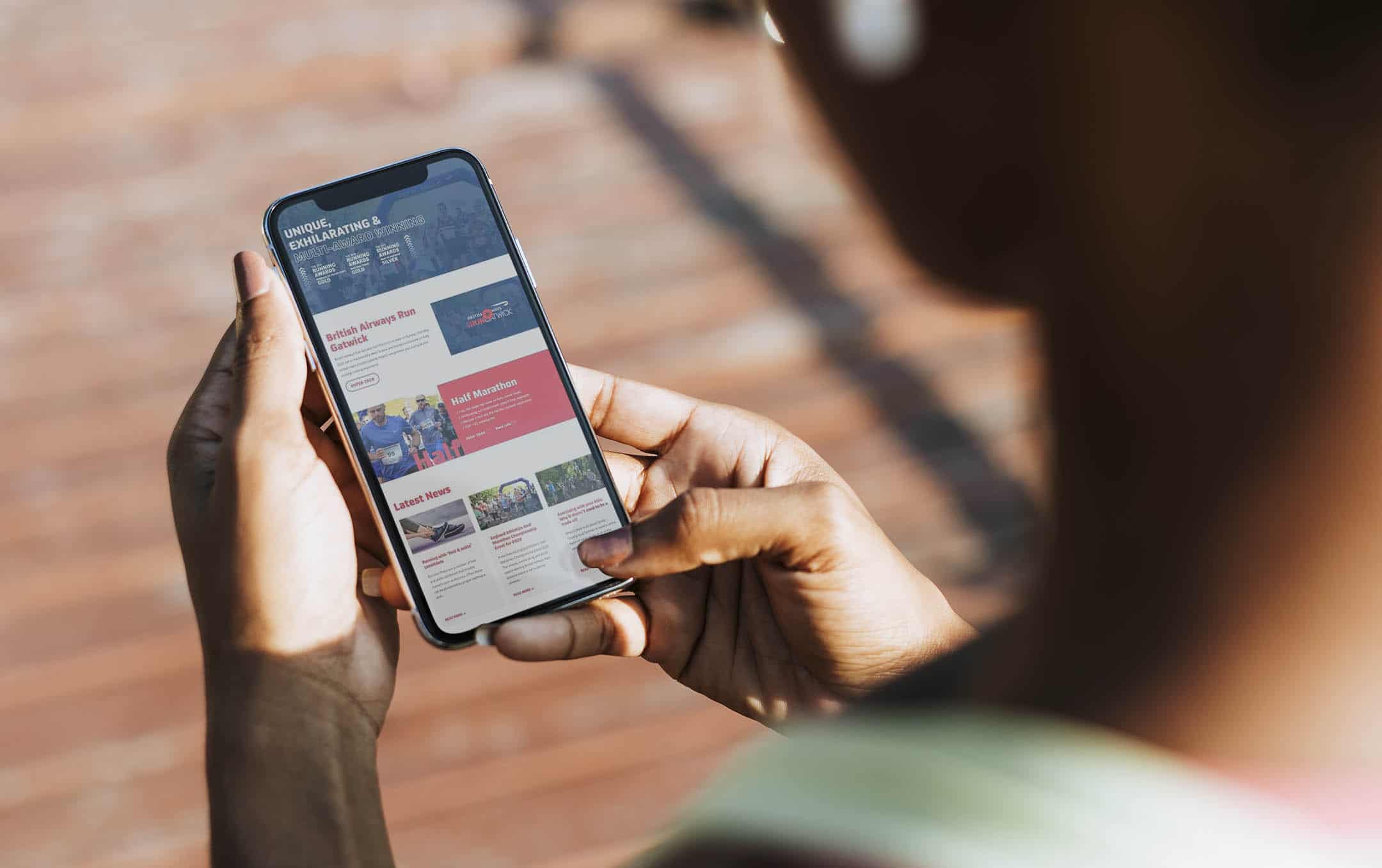 A smartphone user browsing the Run Gatwick website