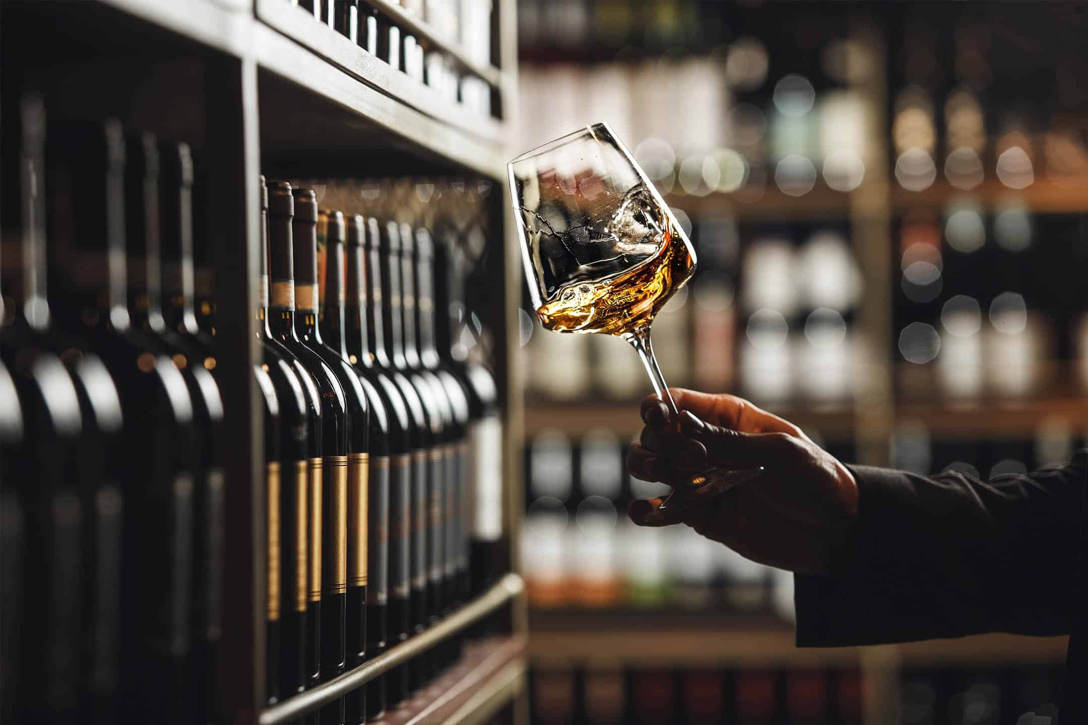 A man swirling whiskey in a glass