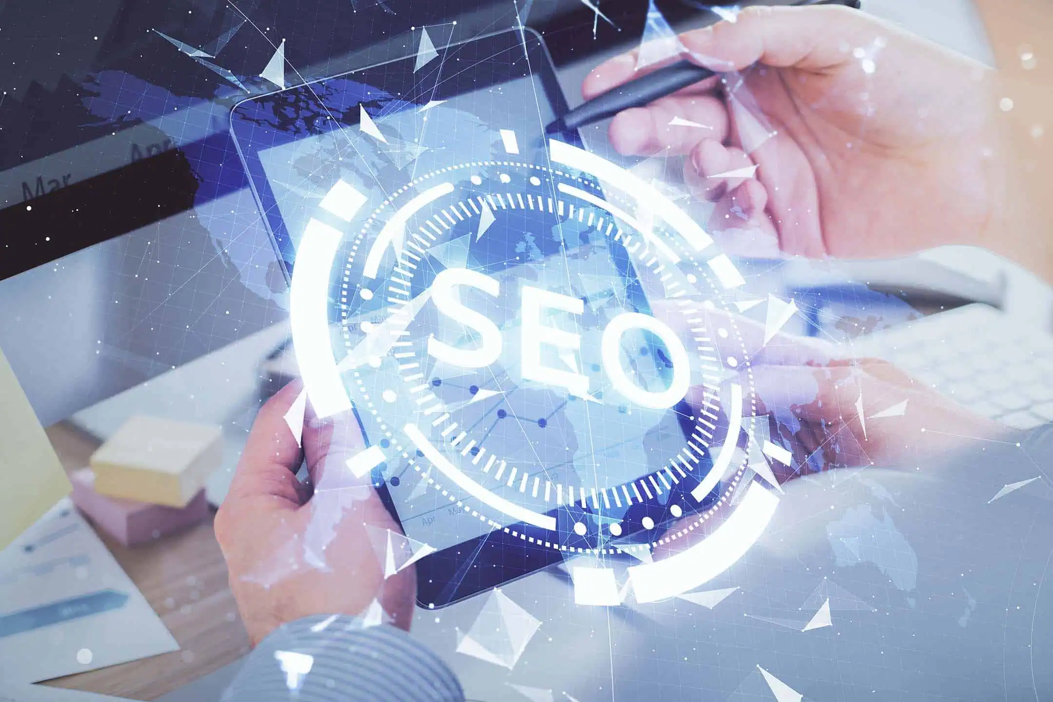 A man holding a tablet below a superimposed graphic of the word SEO